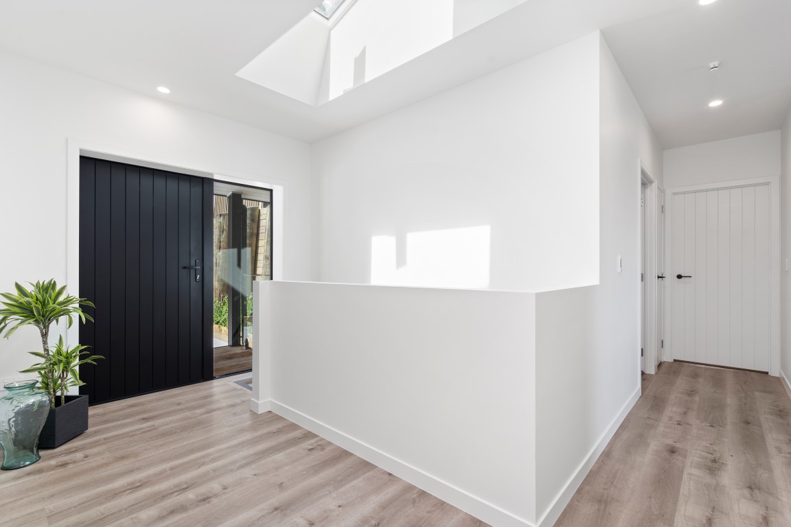 entry-black-front-door-vertical-groove-white-skylight-above-stairs-arcline-architecture