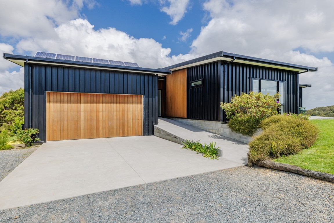 Black-house-cedar-garage-door-metdek-cladding-paroa-bay-view-arcline-architecture