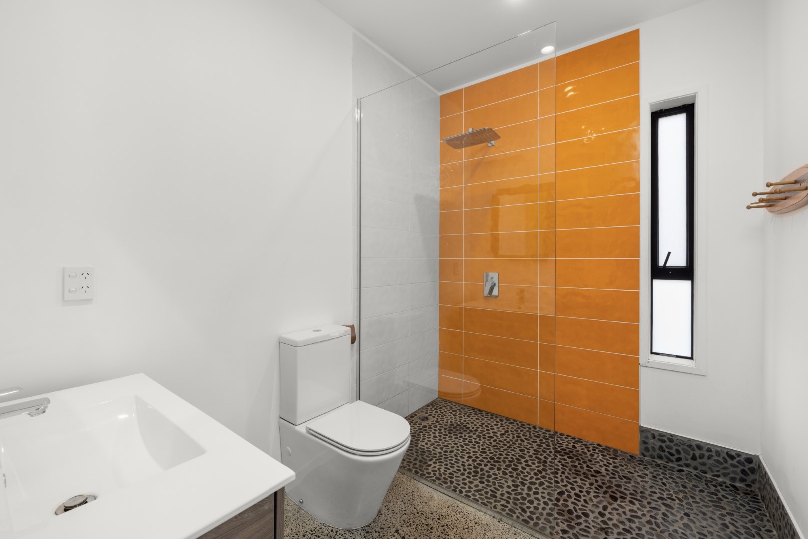white-bathroom-orange-tiles-open-glass-shower-flooring-arcline-architecture.