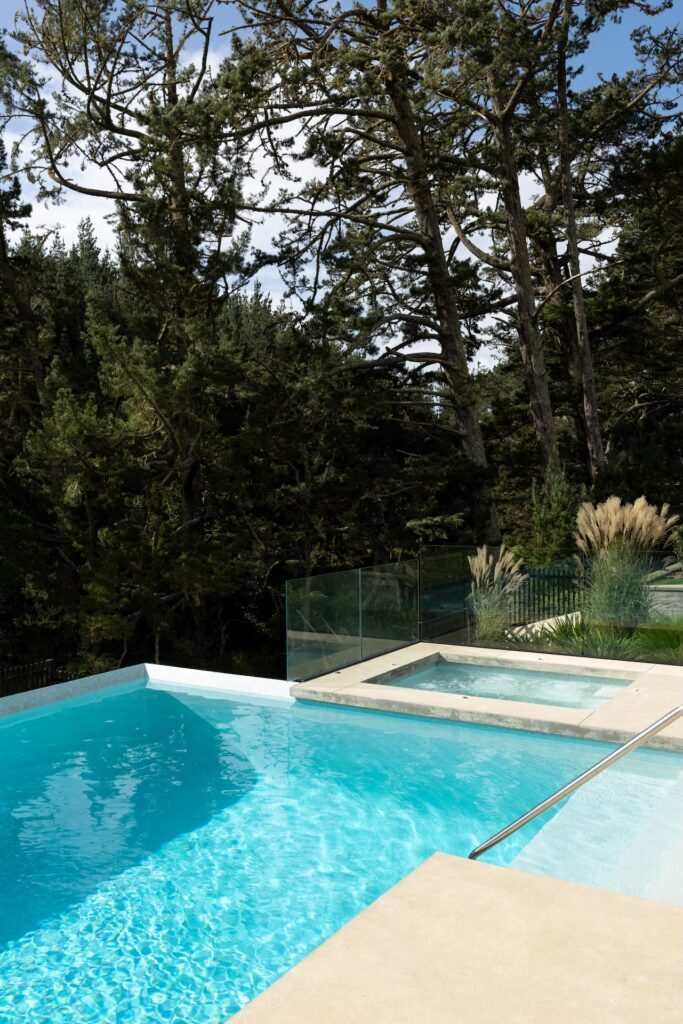 arcline-architecture-infinity-pool-and-spa-with-glass-fencing-and-native-bush-backdrop
