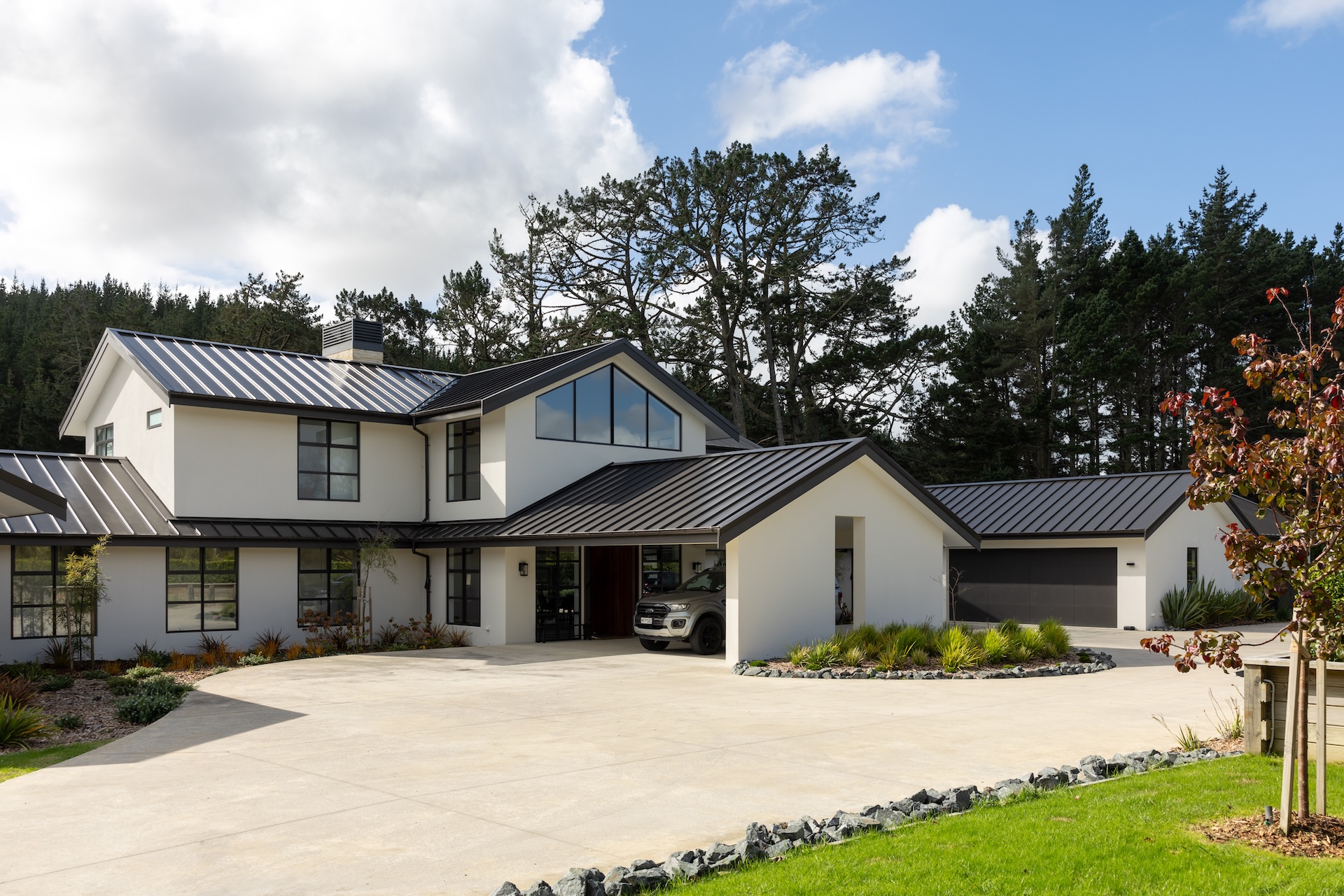 arcline-architecture-modern-farmhouse-front-facade-with-black-metal-roof-and-double-garage