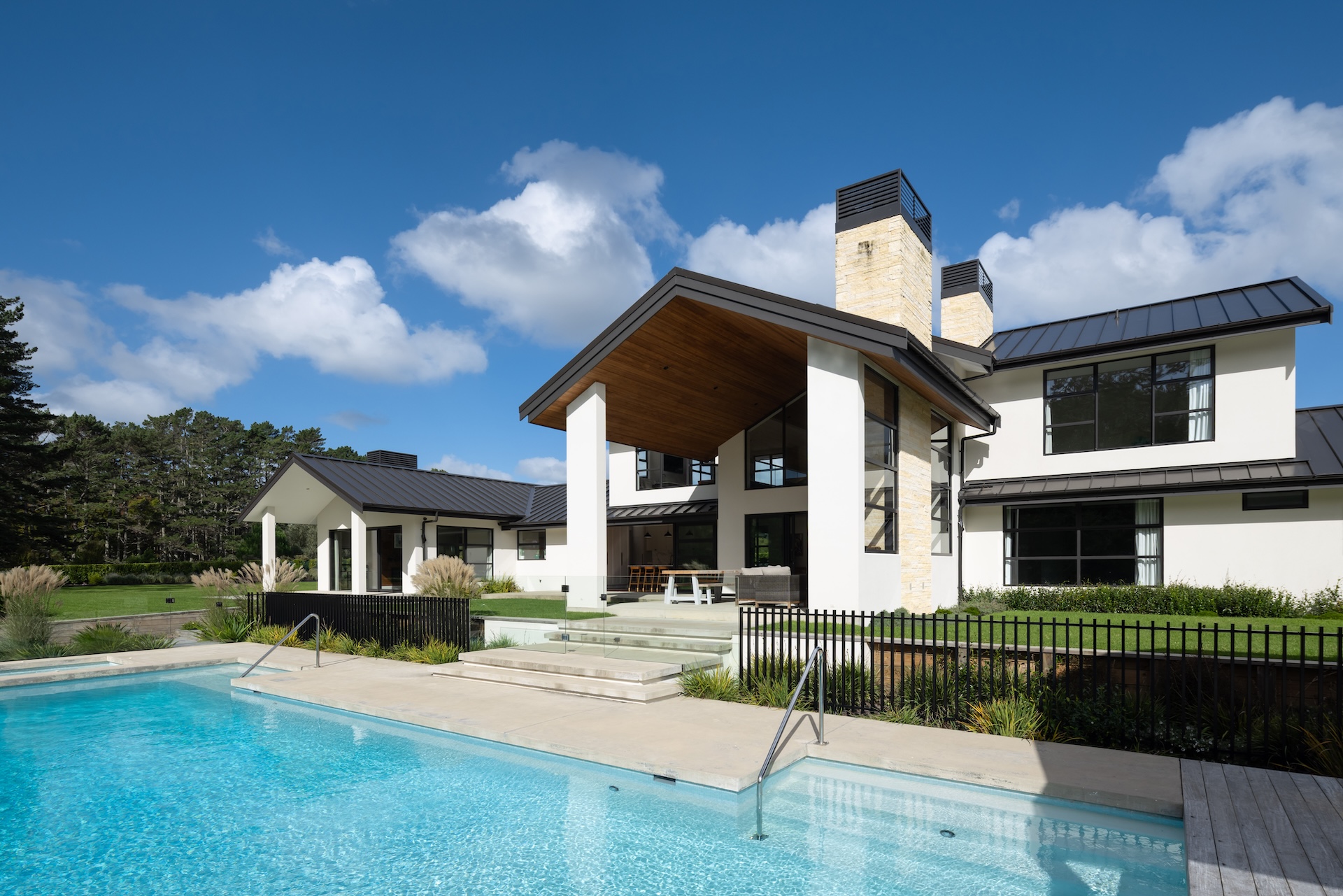 arcline-architecture-rear-exterior-with-pool-timber-ceiling-pavilion-and-stone-chimneys