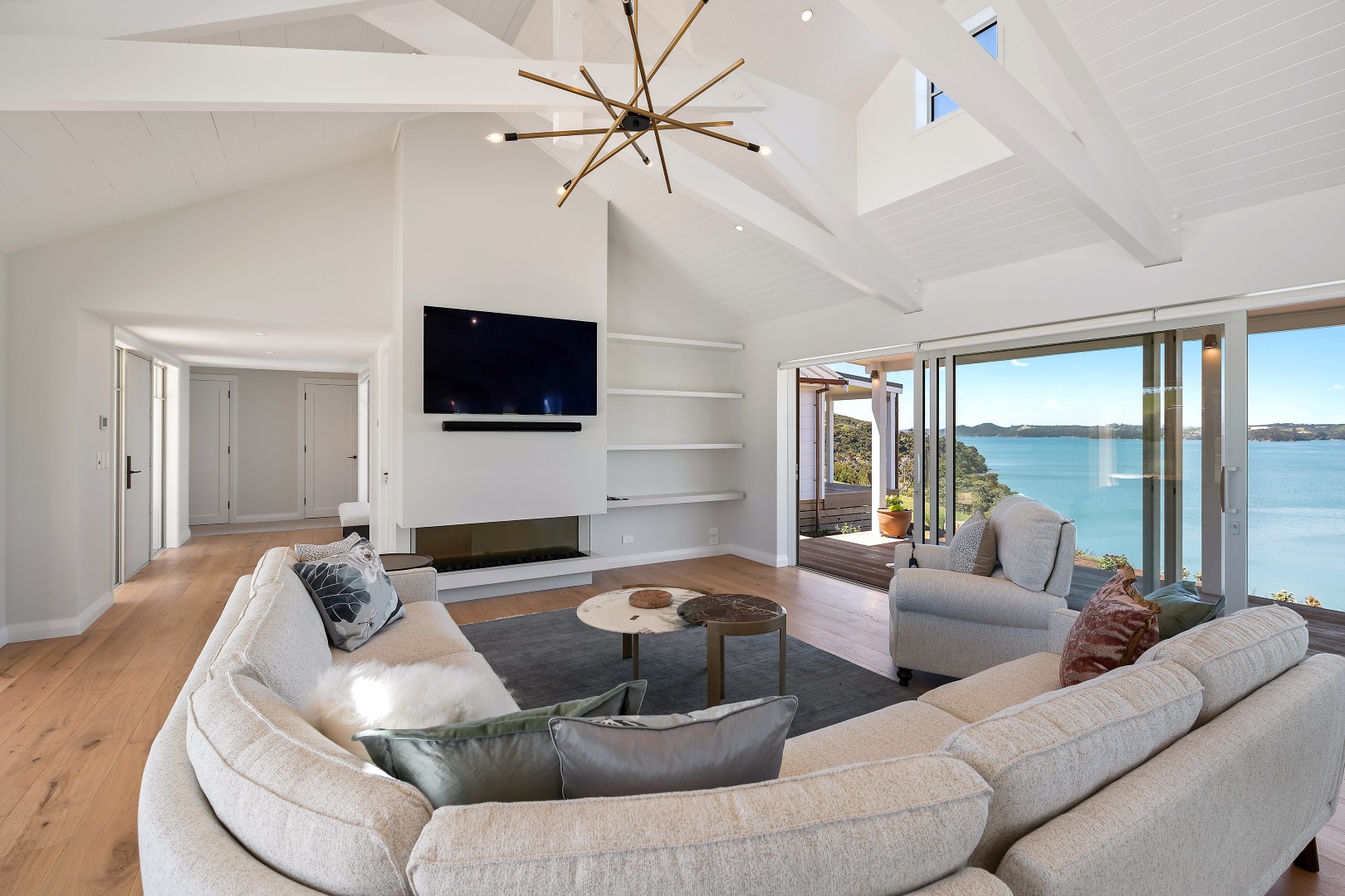 arcline-architecture-wiroa-station-residence-living-room-fireplace-scissor-trusses-bay-of-islands-view