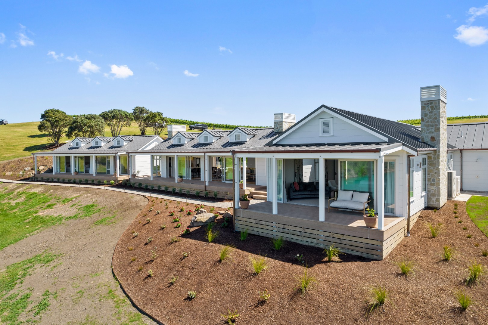 arcline-architecture-wiroa-station-residence-veranda-millboard-decking-stone-chimney-dormers