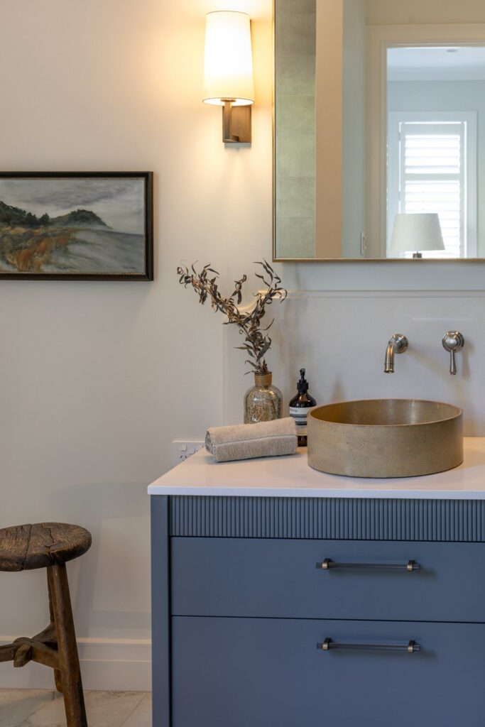 bathroom-vanity-detail-with-stone-vessel-basin-and-wall-sconce-arcline-architecture