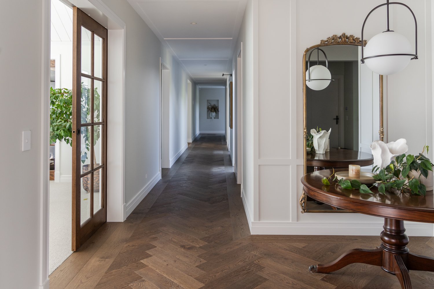 hallway-with-herringbone-floor-and-ornate-mirror-console-table-arcline-architecture