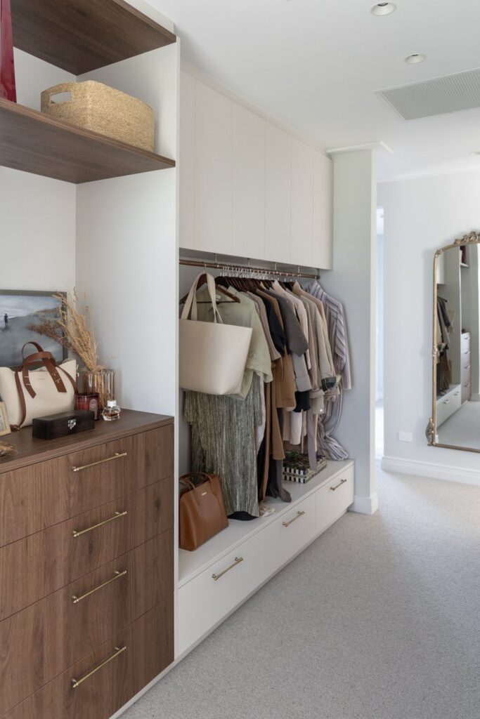 walk-in-wardrobe-with-walnut-drawers-and-clothing-rail-arcline-architecture